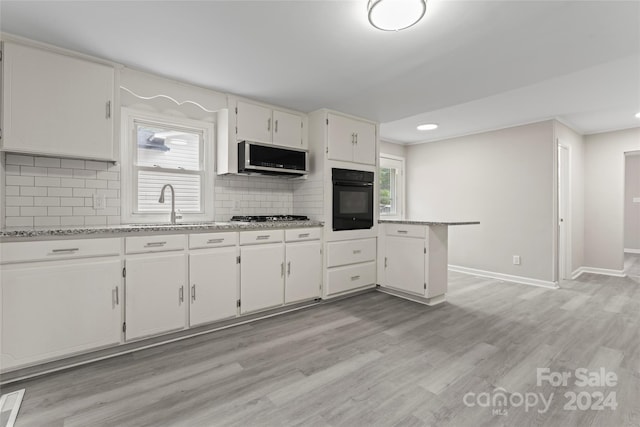 kitchen with white cabinets, a wealth of natural light, and appliances with stainless steel finishes