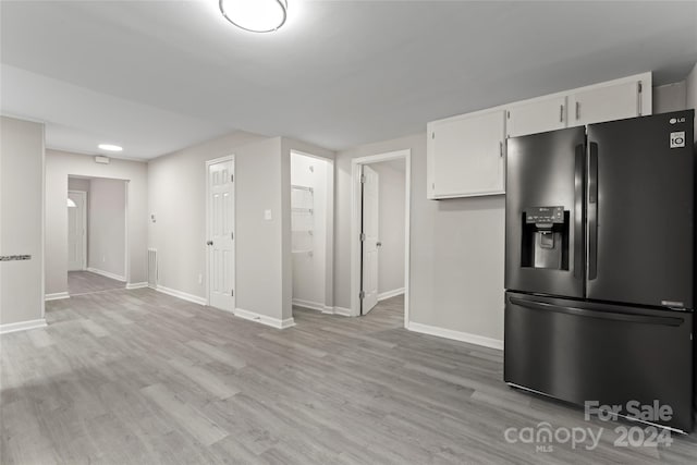 kitchen featuring stainless steel refrigerator with ice dispenser, light hardwood / wood-style floors, and white cabinetry