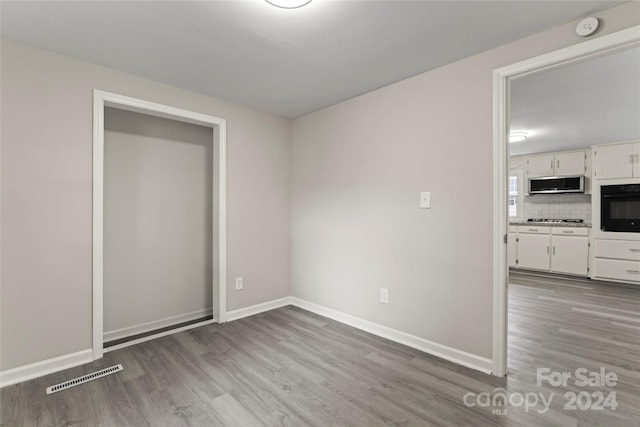 empty room with hardwood / wood-style flooring