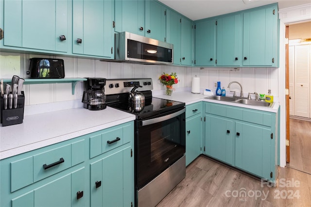 kitchen with light hardwood / wood-style flooring, stainless steel appliances, and sink