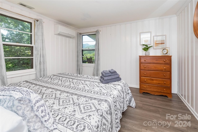 bedroom featuring crown molding, dark hardwood / wood-style flooring, and a wall mounted air conditioner