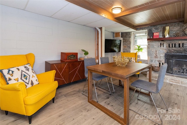 dining room featuring light wood-type flooring and a fireplace