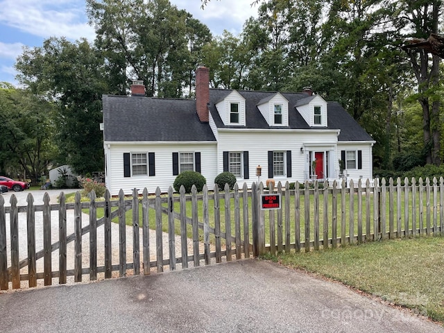 cape cod house featuring a front lawn