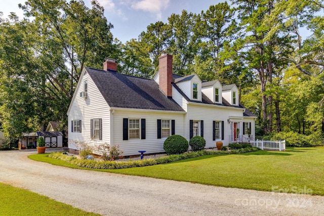 cape cod home featuring a front yard