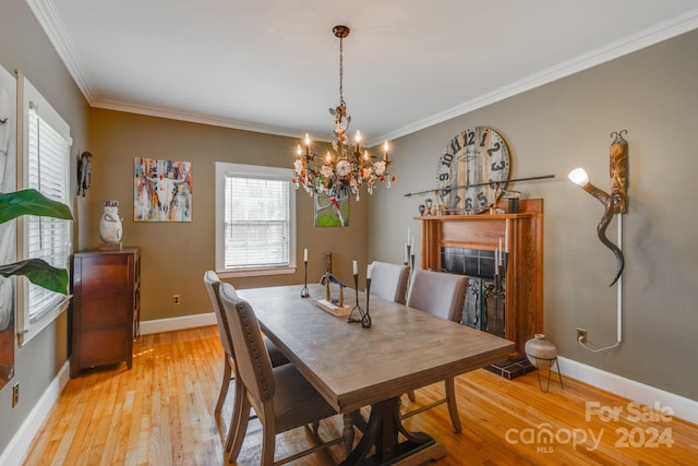 dining area with ornamental molding, a chandelier, and light hardwood / wood-style floors