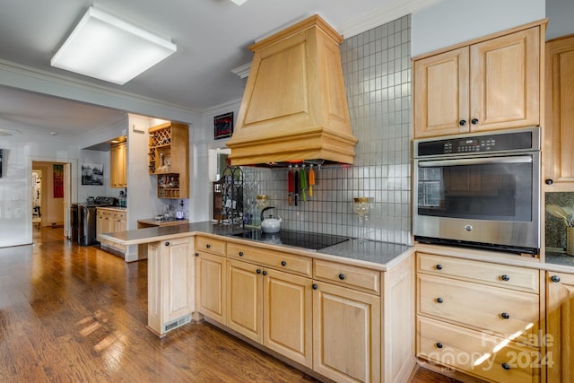 kitchen with dark wood-type flooring, kitchen peninsula, black appliances, crown molding, and custom exhaust hood