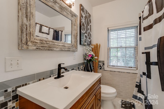 bathroom featuring vanity, tile walls, and toilet