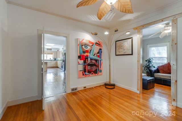 hallway featuring ornamental molding and hardwood / wood-style flooring