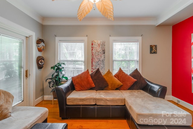 living room featuring crown molding, light hardwood / wood-style floors, and ceiling fan