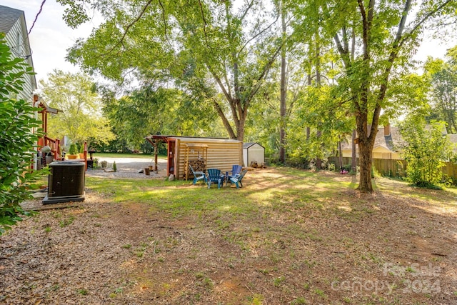 view of yard featuring cooling unit and a storage unit