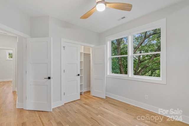 unfurnished bedroom with a closet, light hardwood / wood-style flooring, and ceiling fan