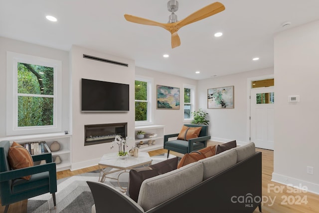 living room with ceiling fan and light hardwood / wood-style flooring