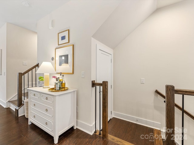 hallway featuring dark wood-type flooring and lofted ceiling