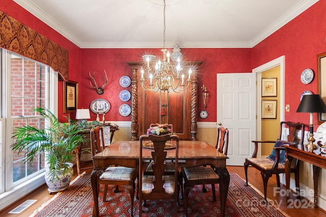 dining area featuring hardwood / wood-style flooring, a chandelier, and crown molding