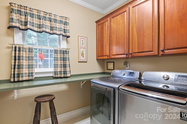 laundry room with washer and dryer, cabinets, and crown molding