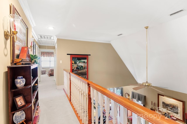 hall with vaulted ceiling, ornamental molding, and light carpet