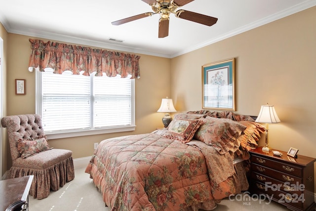 carpeted bedroom with ceiling fan and ornamental molding