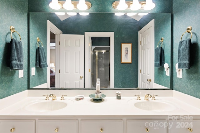 bathroom featuring a shower with door and vanity