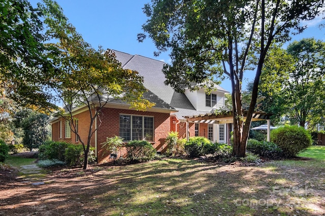 view of front of home with a pergola and a front yard