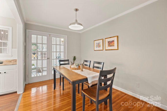 dining room featuring crown molding, light hardwood / wood-style floors, and french doors