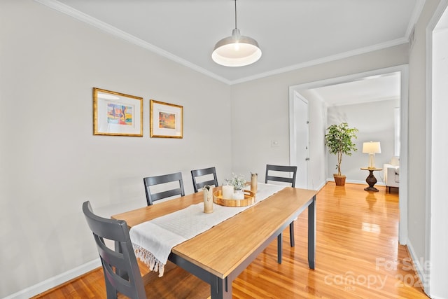 dining space with wood-type flooring and crown molding