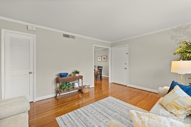 living room featuring hardwood / wood-style flooring and ornamental molding