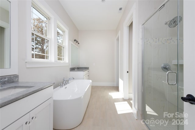 bathroom with shower with separate bathtub, vanity, and wood-type flooring