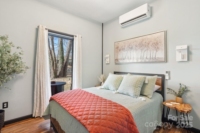 bedroom with wood-type flooring and a wall unit AC