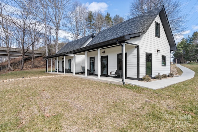 back of property featuring a patio area, covered porch, and a lawn