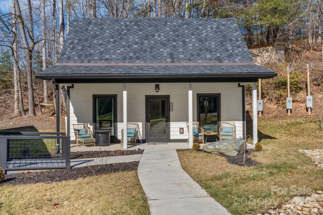 view of front of property featuring covered porch and a front lawn