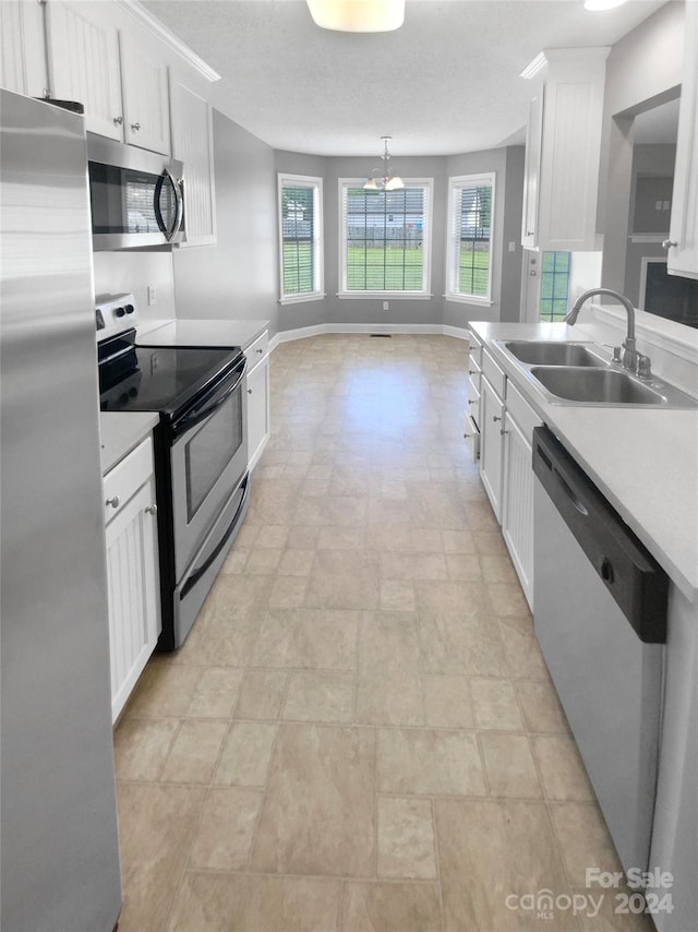 kitchen with a chandelier, decorative light fixtures, sink, appliances with stainless steel finishes, and white cabinets