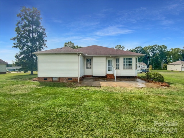 back of property featuring a patio area and a lawn