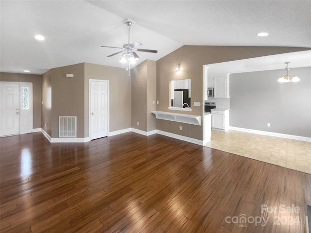 unfurnished living room featuring ceiling fan with notable chandelier, dark wood-type flooring, and lofted ceiling