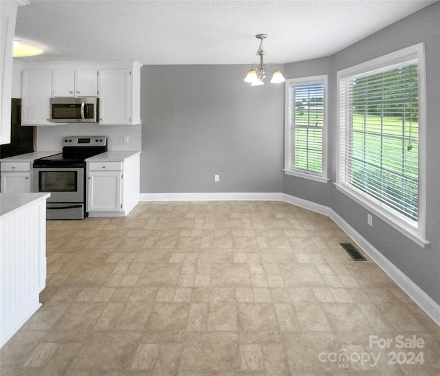 kitchen featuring hanging light fixtures, stainless steel appliances, an inviting chandelier, and white cabinetry