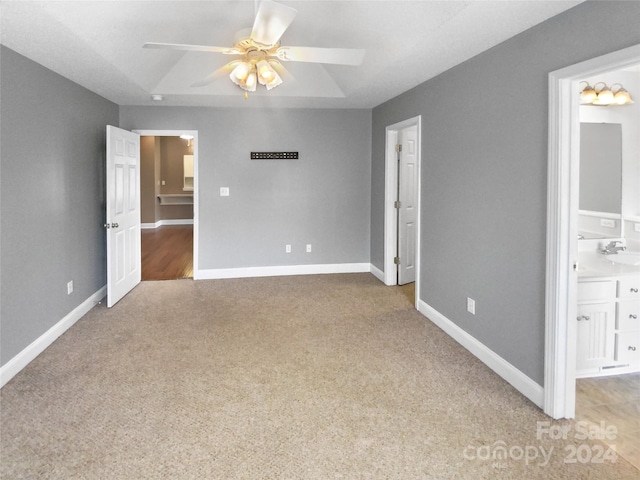 unfurnished bedroom featuring ceiling fan, sink, light carpet, and connected bathroom