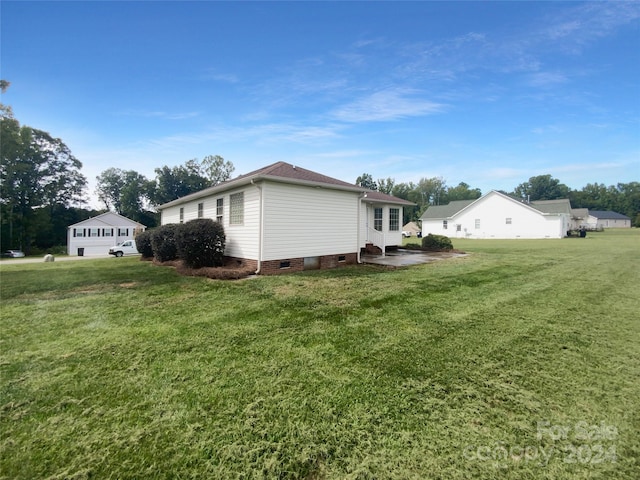 view of side of property with a garage and a lawn