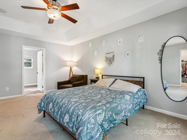 carpeted bedroom with a spacious closet, a closet, and ceiling fan