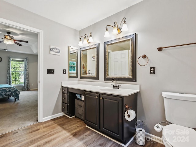 bathroom with vanity, wood-type flooring, toilet, and ceiling fan