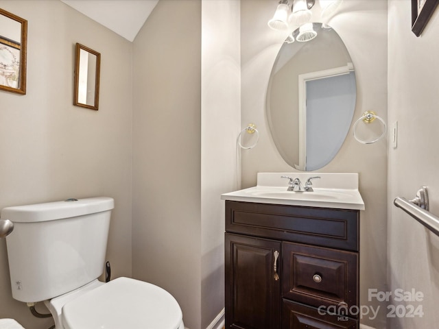 bathroom featuring vanity, vaulted ceiling, and toilet