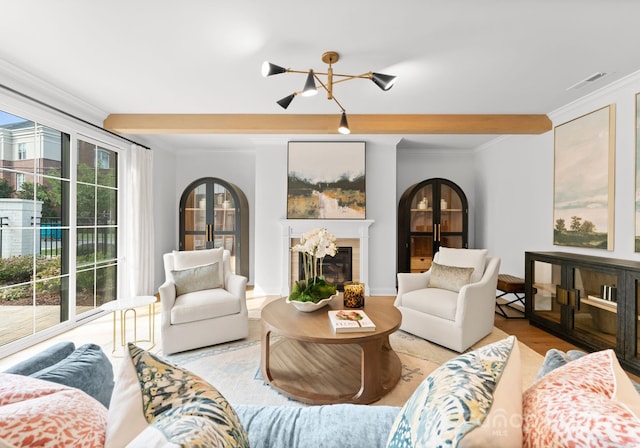 living room with ornamental molding, light hardwood / wood-style flooring, and an inviting chandelier