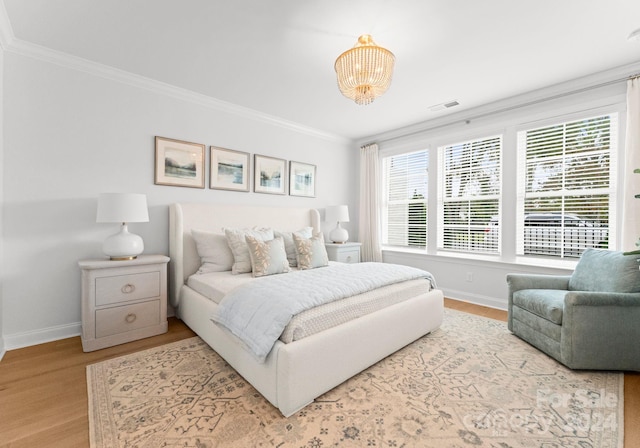 bedroom featuring a notable chandelier, hardwood / wood-style floors, and crown molding