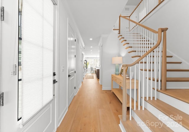 entryway featuring light hardwood / wood-style flooring and crown molding