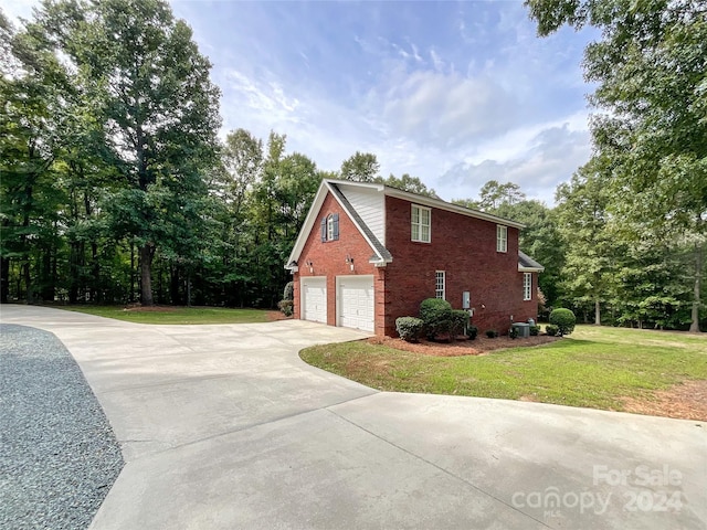 view of side of home featuring a garage and a lawn