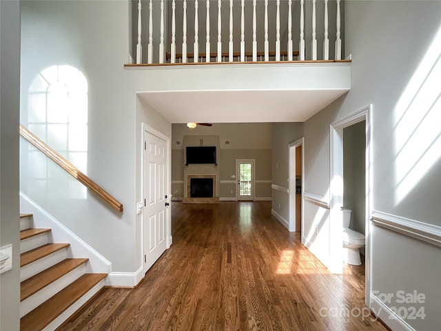 interior space featuring a towering ceiling and dark hardwood / wood-style flooring