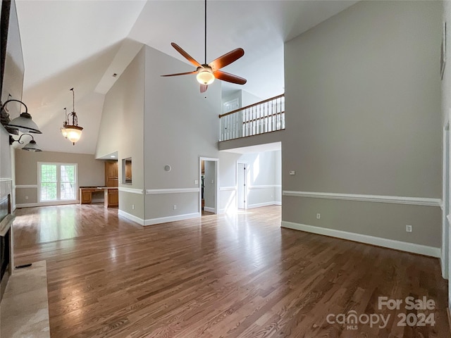 unfurnished living room with high vaulted ceiling, hardwood / wood-style flooring, and ceiling fan