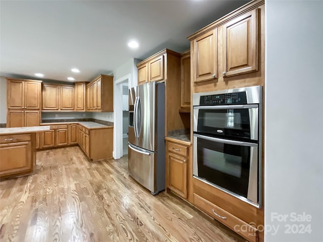 kitchen with stainless steel appliances and light hardwood / wood-style floors