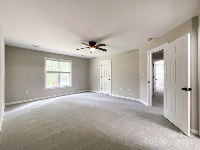 carpeted spare room with ceiling fan