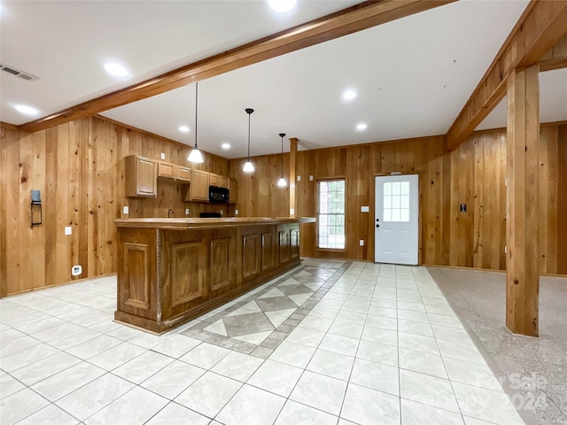 kitchen with a center island, hanging light fixtures, and wooden walls