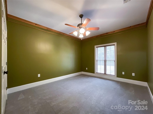 empty room with crown molding, ceiling fan, and carpet floors