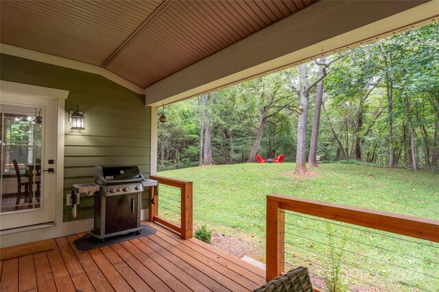 deck featuring a view of trees, area for grilling, and a yard